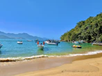 a beach with boats and people