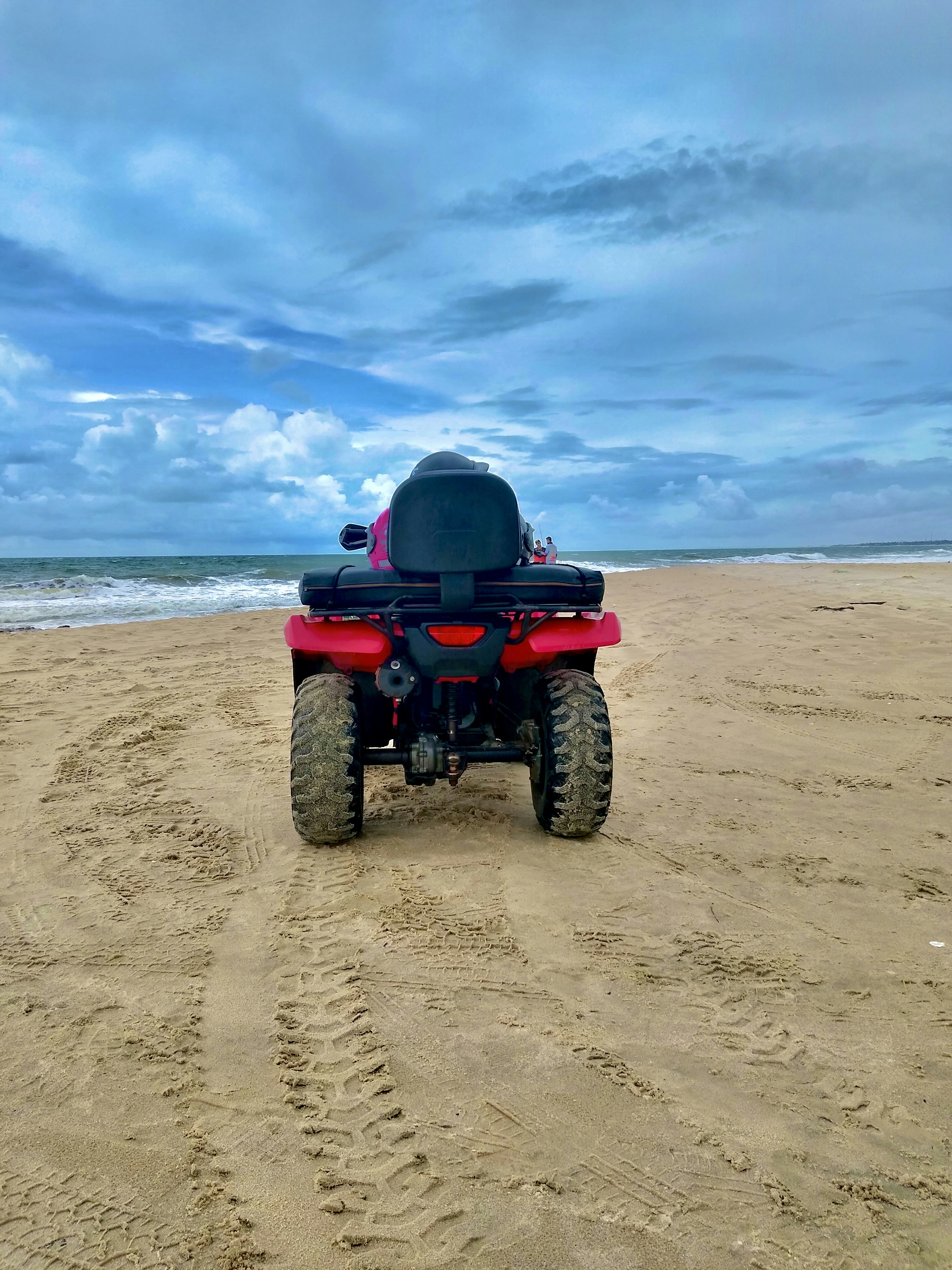 a red and black vehicle on a sandy beach