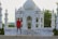 A smiling guest standing outside Birla Dharamshala with the Ayodhya temple faintly visible in the background.