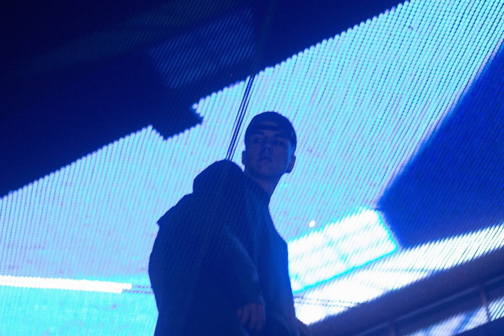 a man standing in front of a blue light