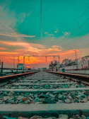 Aerial view of the rail line tracing through the foothills toward the Great Smoky Mountains at sunset.