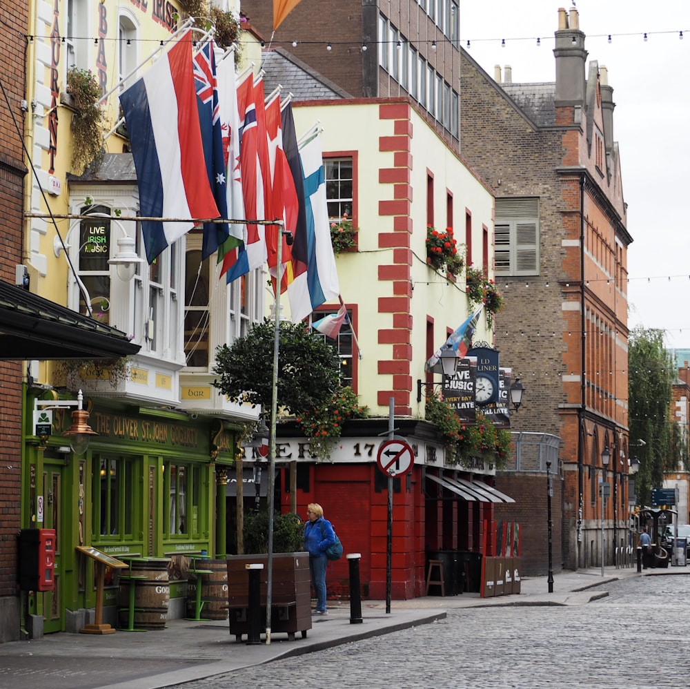 a person walking down a street with flags on the side