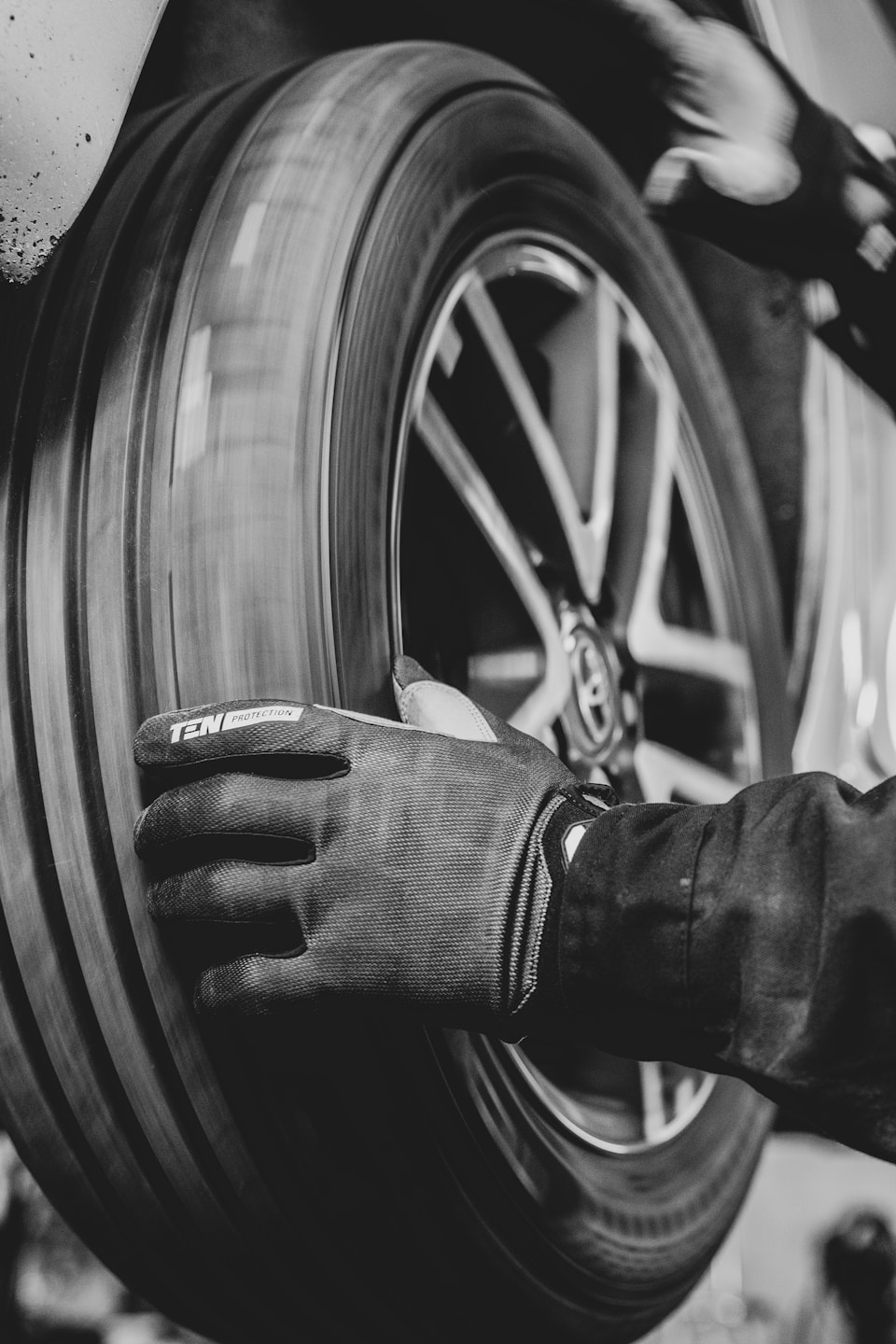 Image of a car tire in motion being inspected by a car mechanic