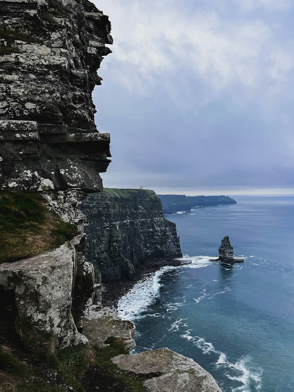 a rocky cliff next to a body of water