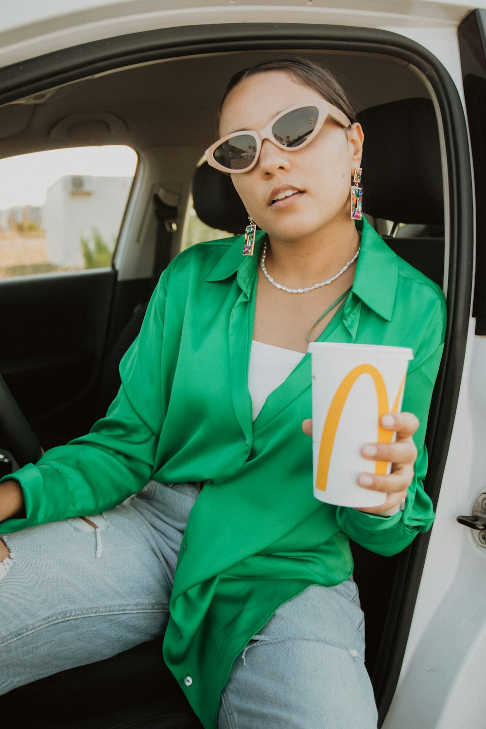 a woman holding a book and sitting in a car