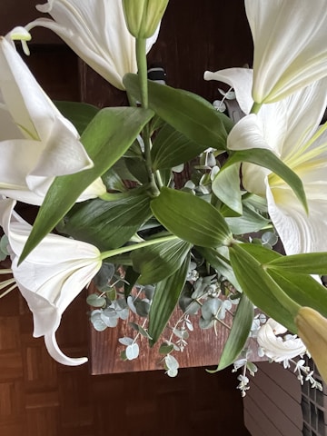 Elegant wedding floral arrangement with white lilies and eucalyptus leaves.