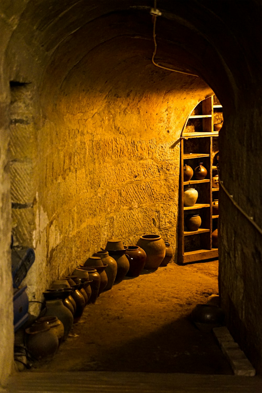 a room with a shelf and pots