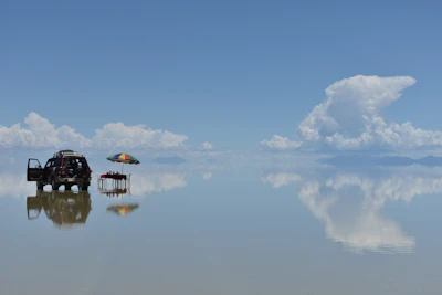 A vehicle reflected on the flooded mirror surface of the Salar de Uyuni