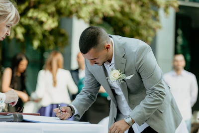 a person in a suit signing a document