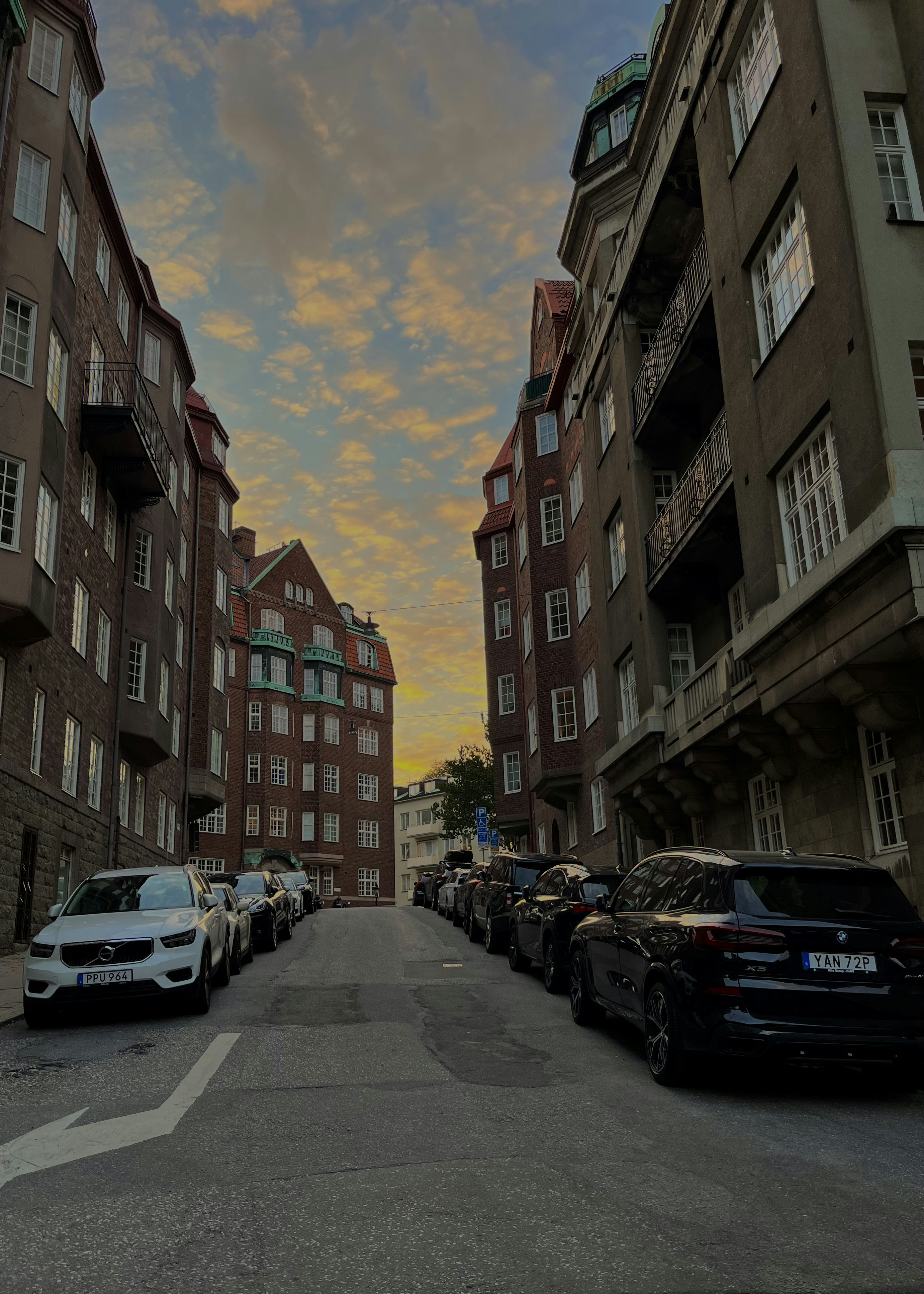 A street with cars parked on it and buildings on the side photo – Free ...