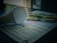A light bulb is placed on top of a stack of paper currency and paperwork, likely bills or invoices. The scene suggests a focus on electricity costs, with soft lighting creating shadows.