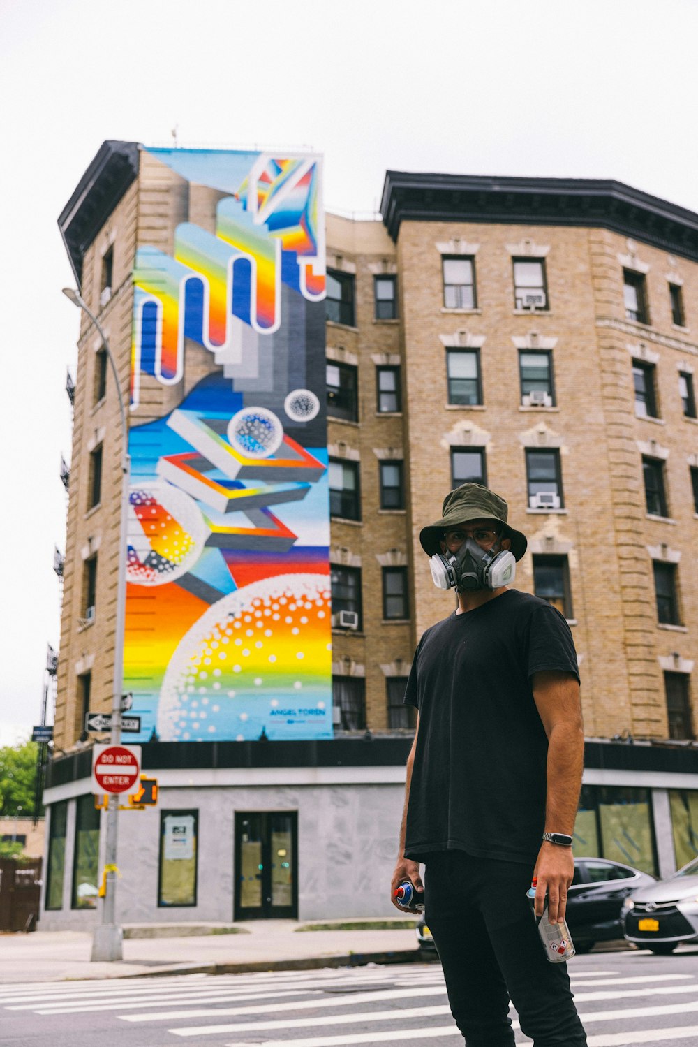 a man wearing a mask and standing in front of a building