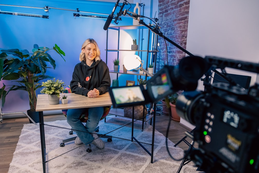 a person sitting at a table with a camera and a camera