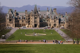 a large building with a lawn in front of it with Biltmore Estate in the background