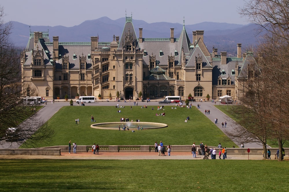 a large building with a lawn in front of it with Biltmore Estate in the background