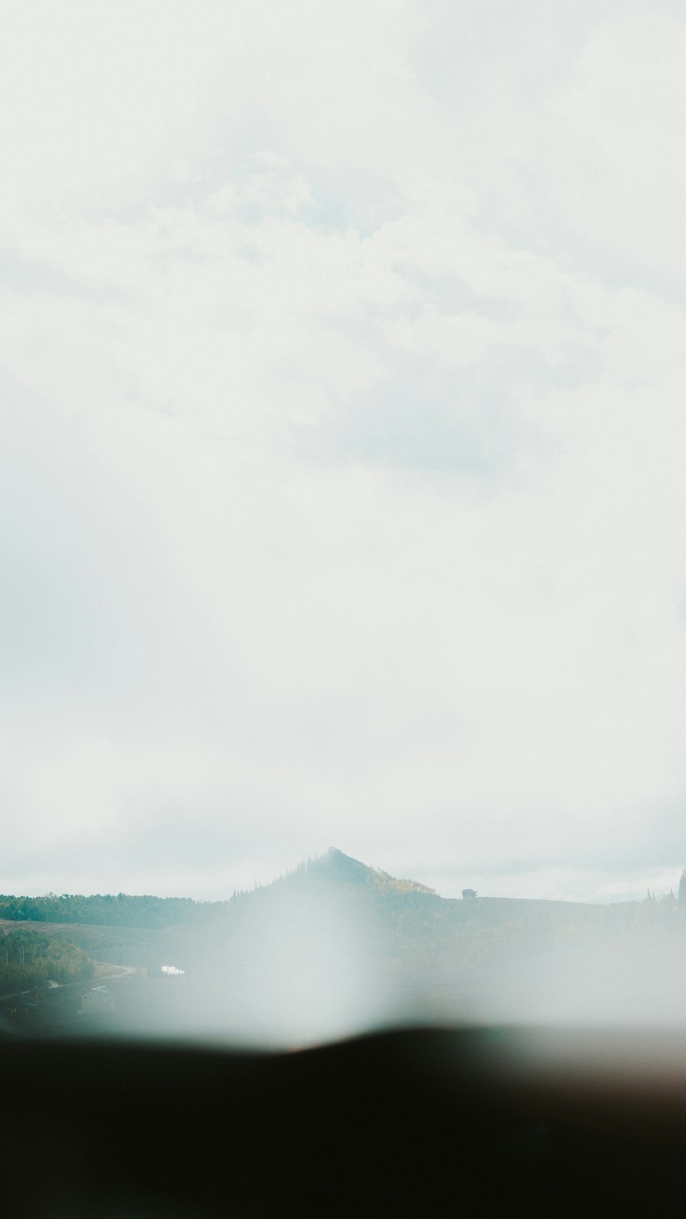 a mountain with a foggy sky