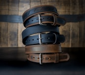 Finished leather wallets and belts neatly stacked, showcasing fine craftsmanship.