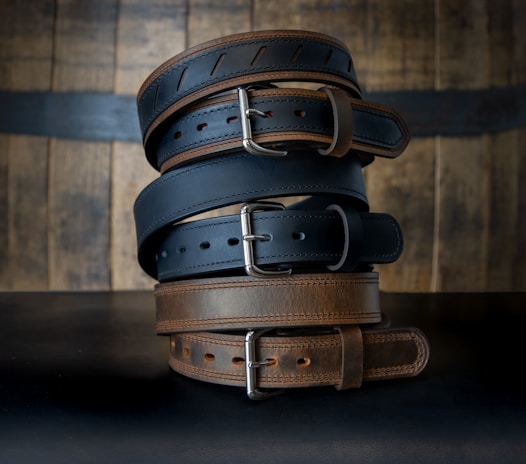 A collection of stylish leather belts displayed elegantly on a wooden table.