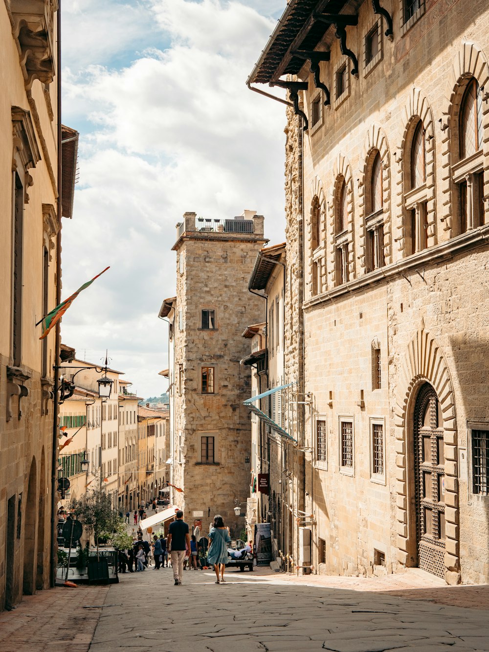 people walking on a street between buildings