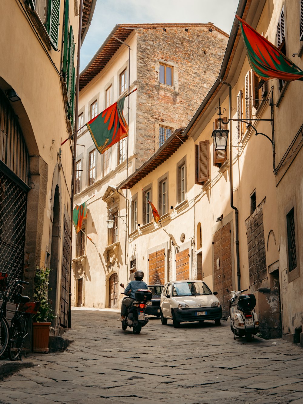 a person riding a motorcycle down a cobblestone street