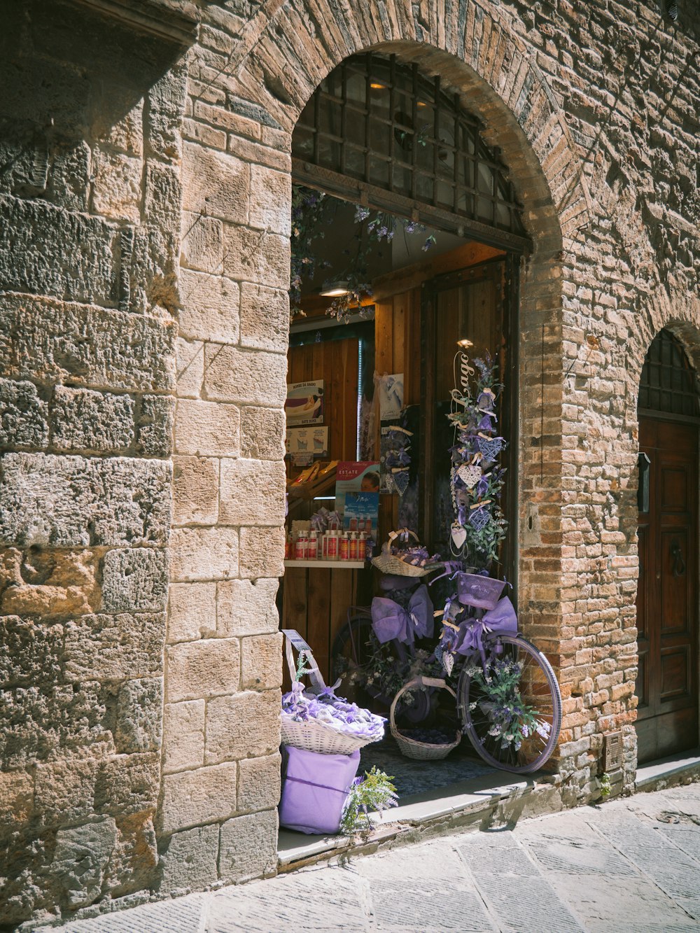 a stone building with a stone archway and a bike rack with flowers