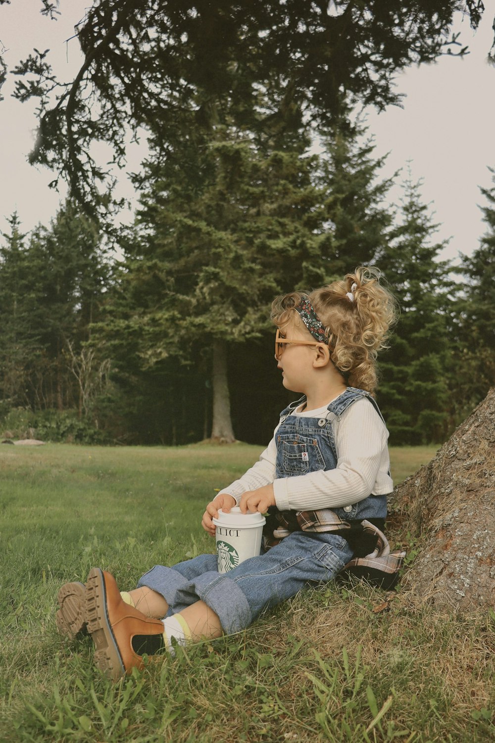 a person sitting on grass with a tree in the background