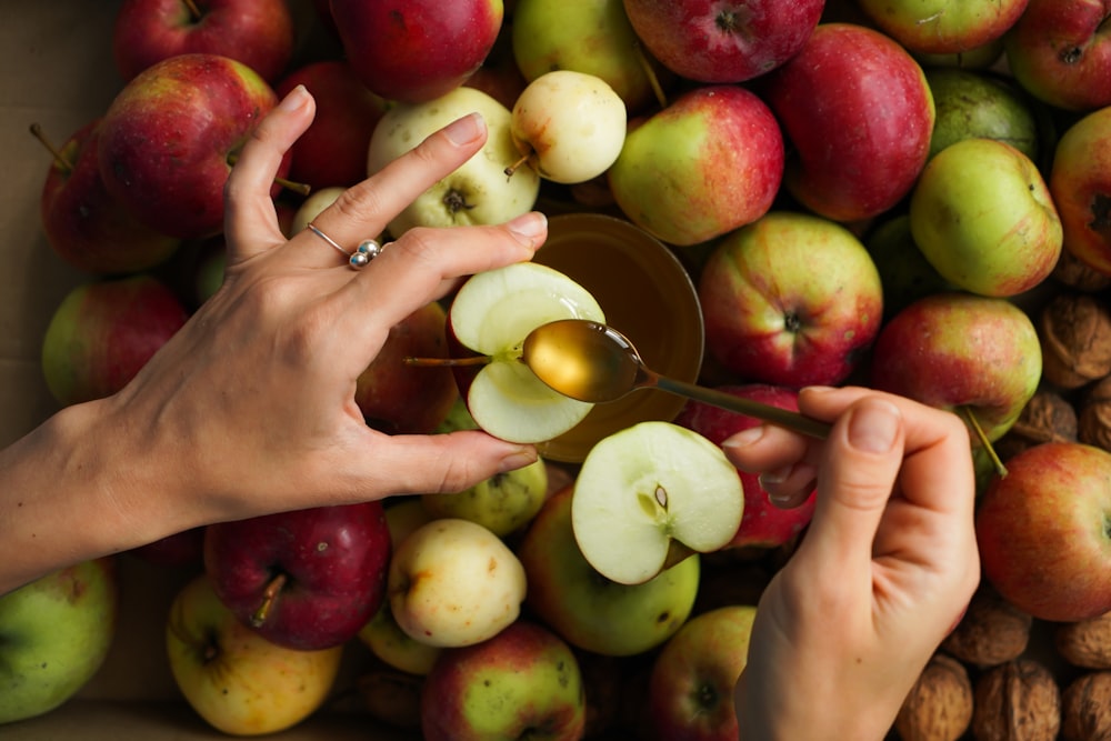 a person holding a bunch of apples