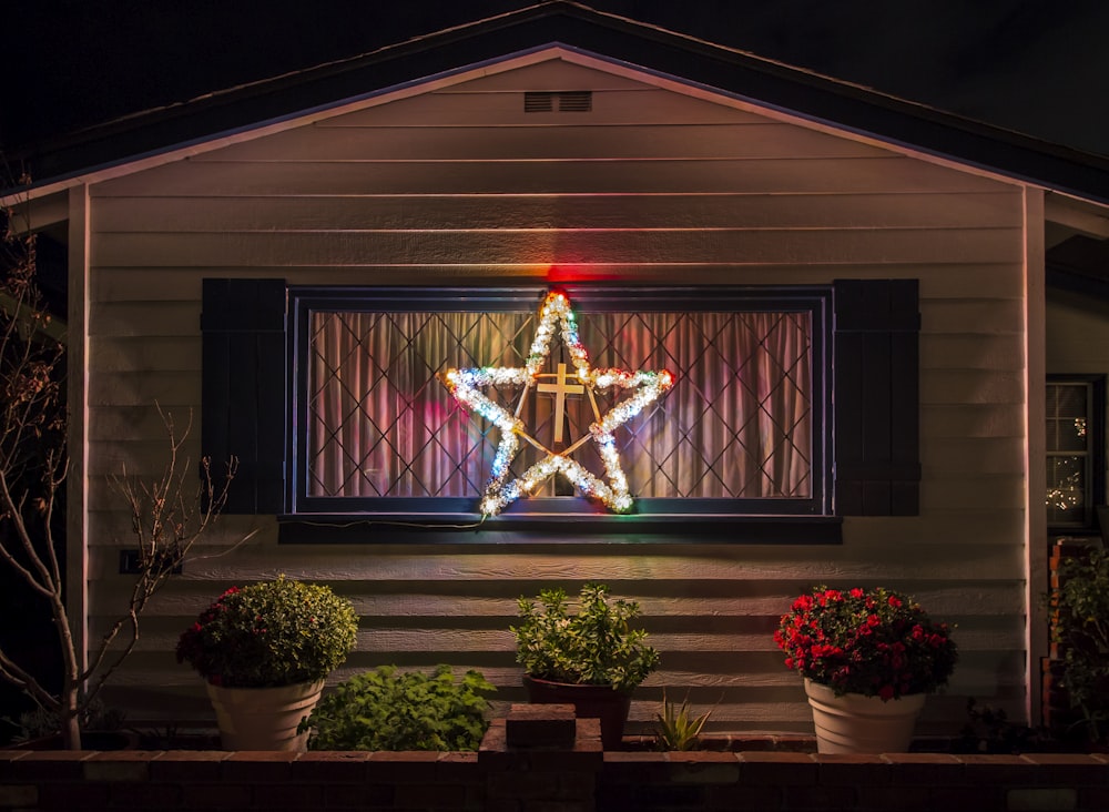 a lit up christmas tree in front of a house