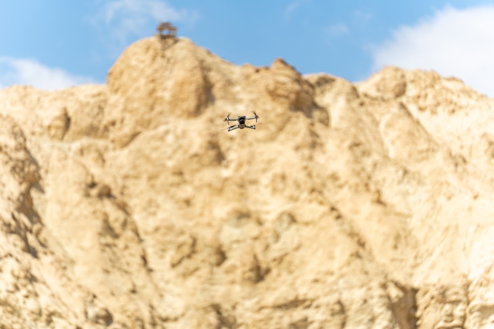 a helicopter flying over a rocky mountain