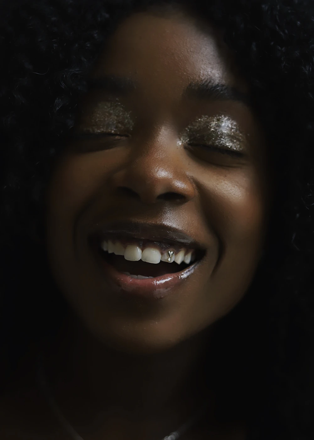 Smiling woman with a sparkling tooth gem