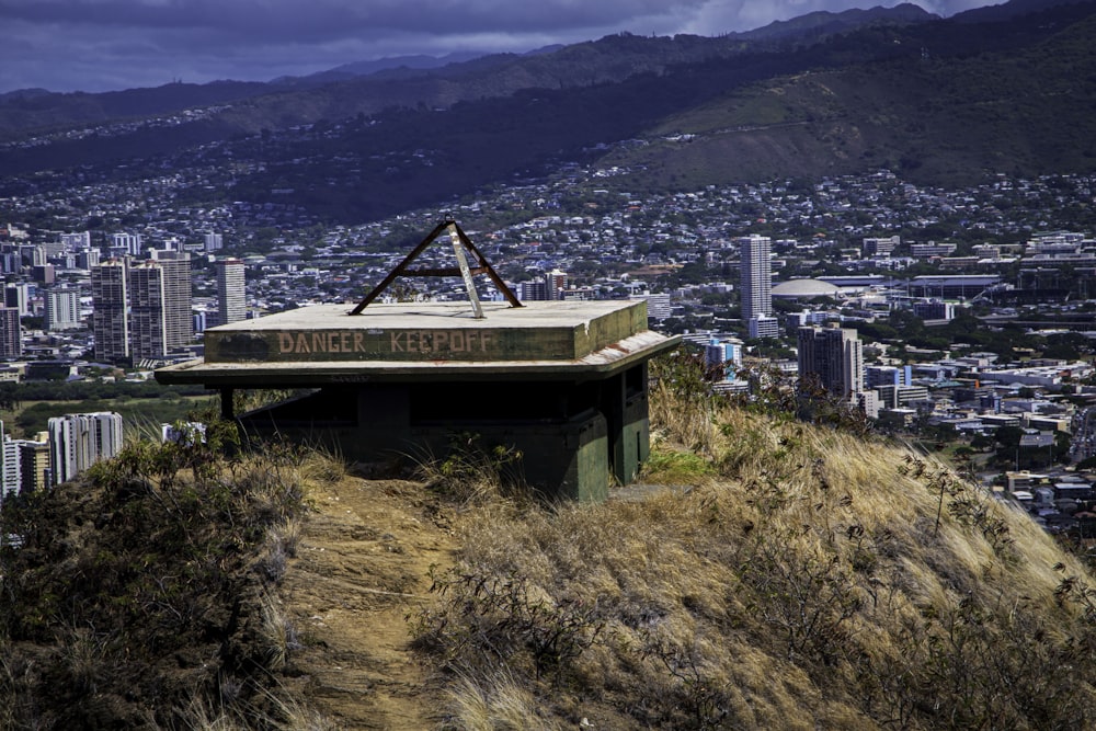 a building on a hill with a city in the background