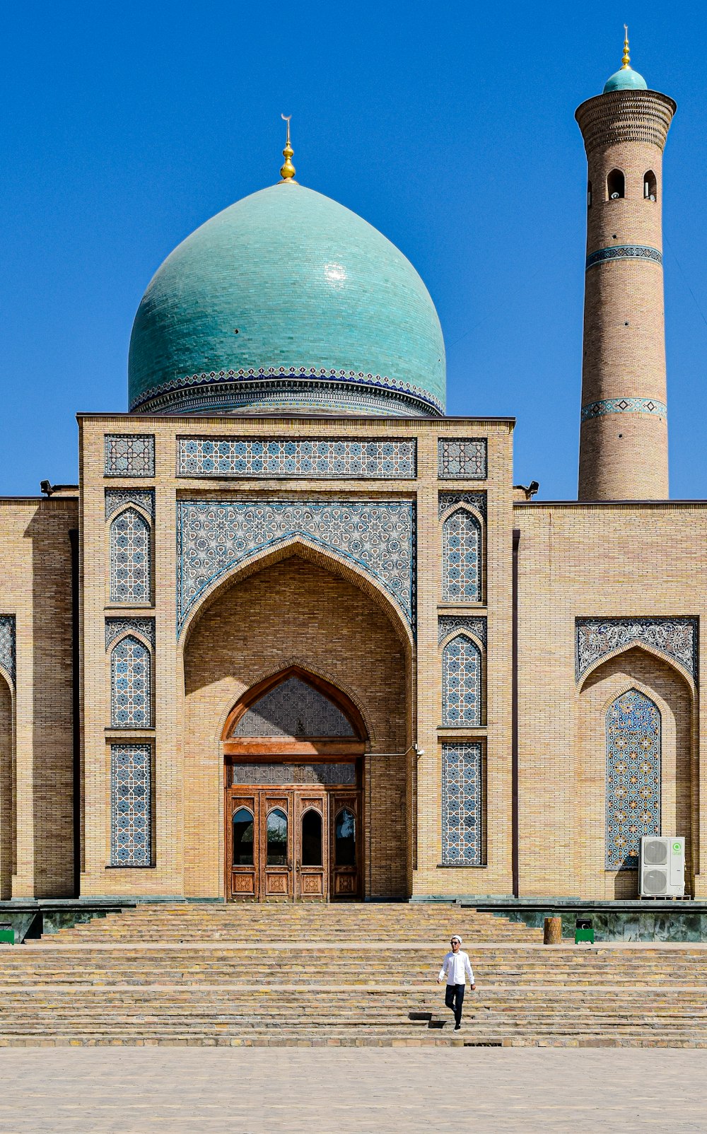 a person standing in front of a building with a green dome