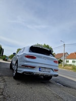 White luxury SUV ready for a city drive with Prague’s historic buildings behind.