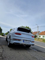 A pristine white SUV parked on a scenic coastal road, ready for delivery in Tirana.