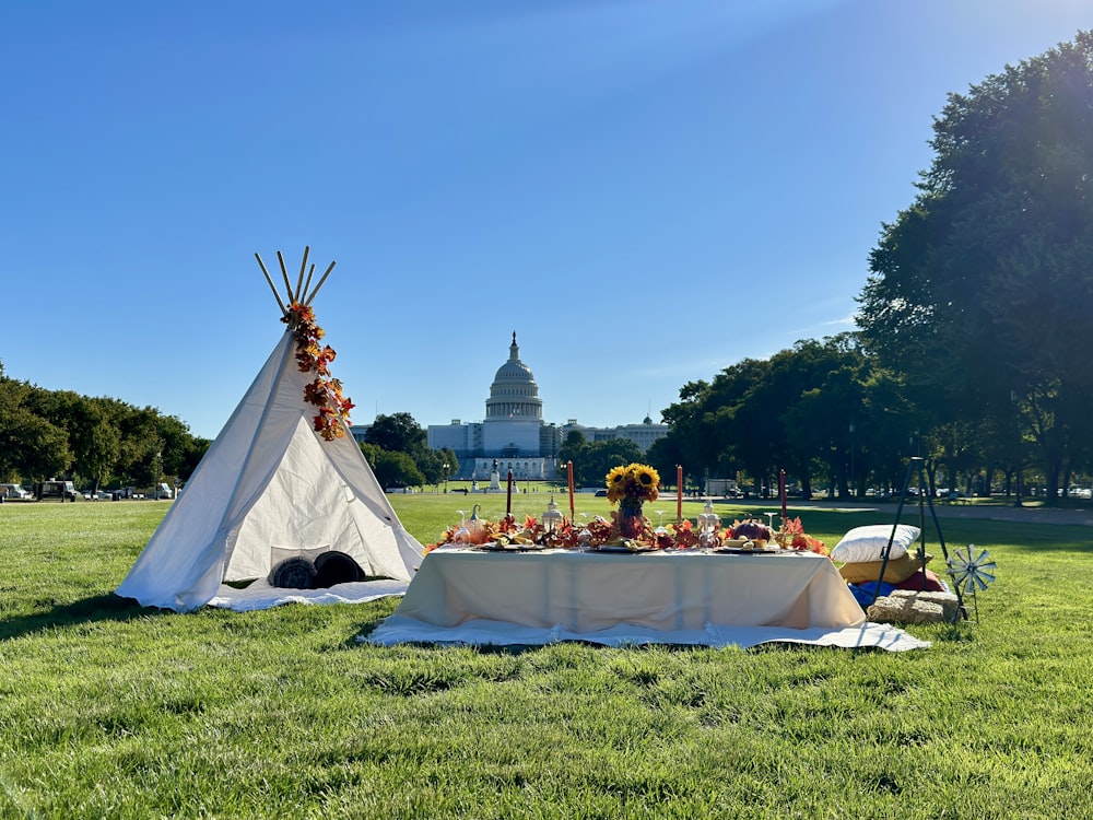 a white tent with flowers in front of a white building