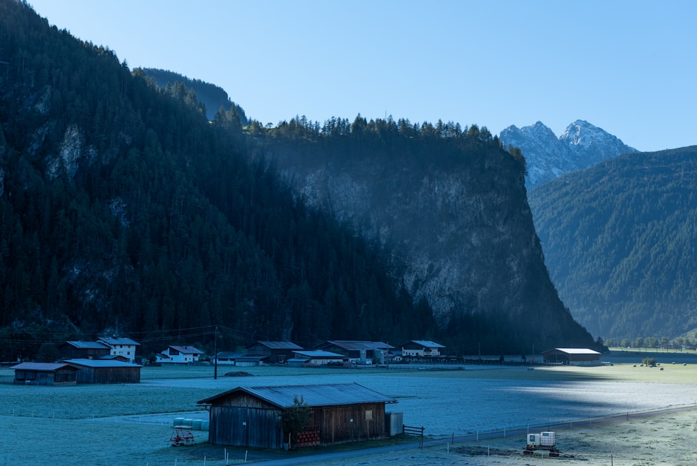 a group of buildings by a body of water with mountains in the background