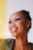 A smiling woman showcasing her flawless makeup and shiny hair.