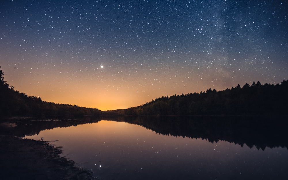 a lake with a starry sky above it