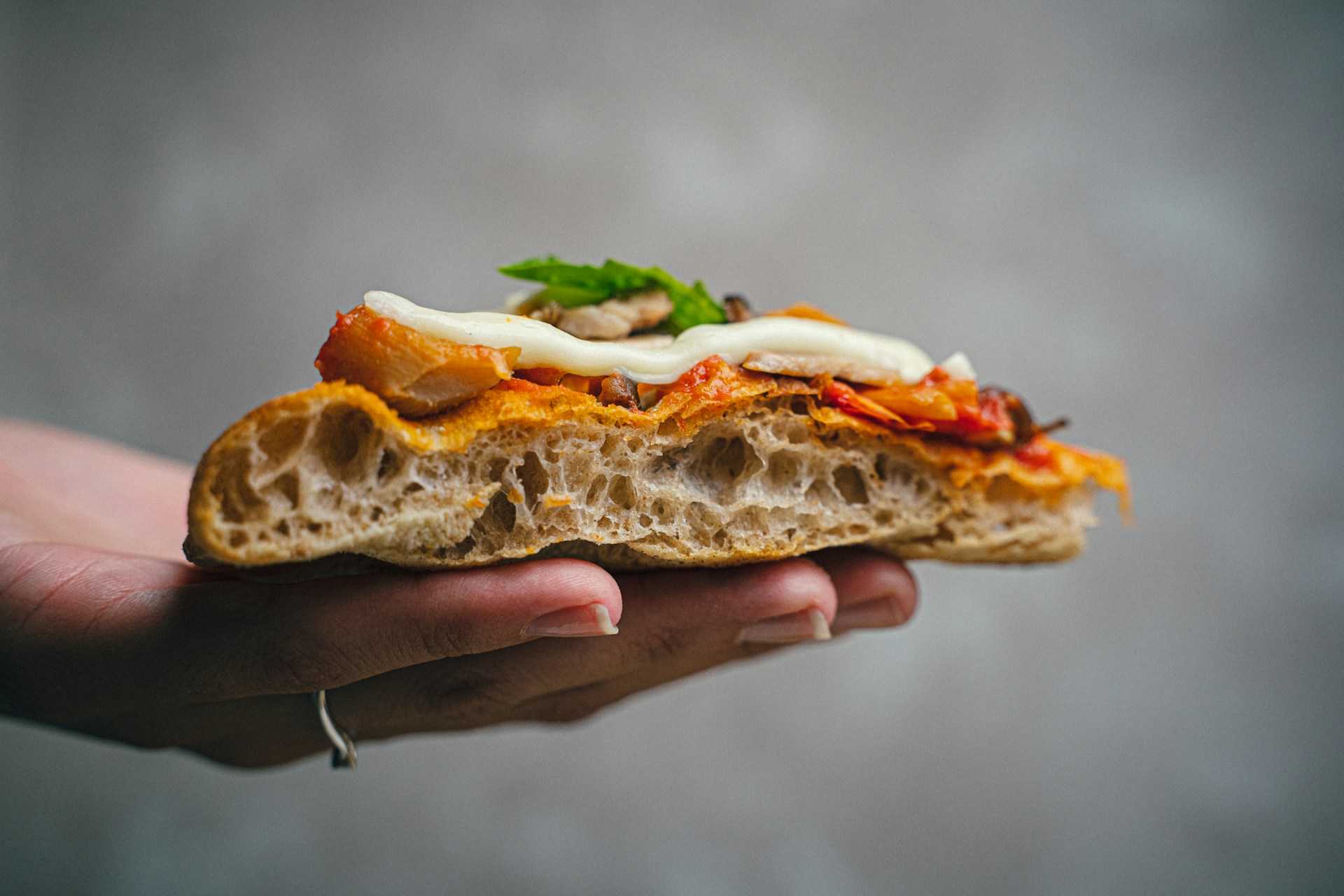 a person holding a sandwich