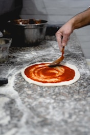 a person slicing a pizza