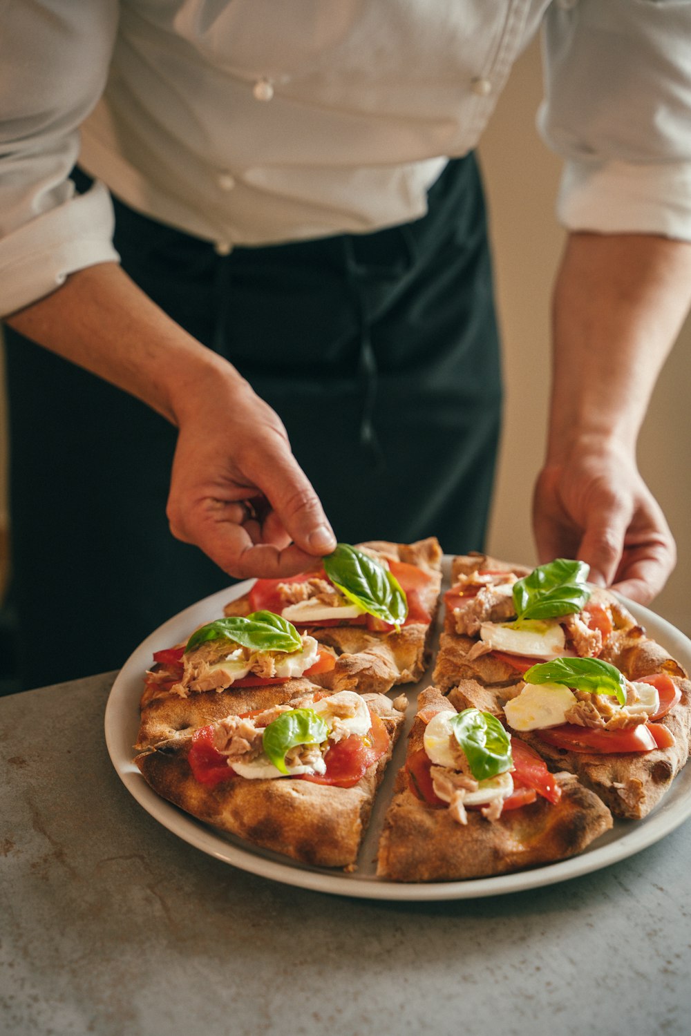 a person cutting a pizza