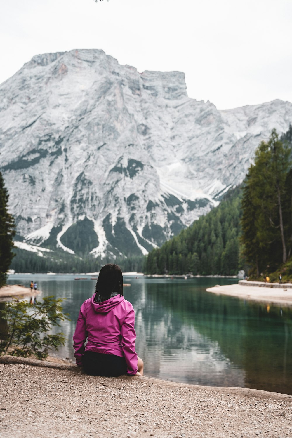 a person sitting on a rock looking at a mountain