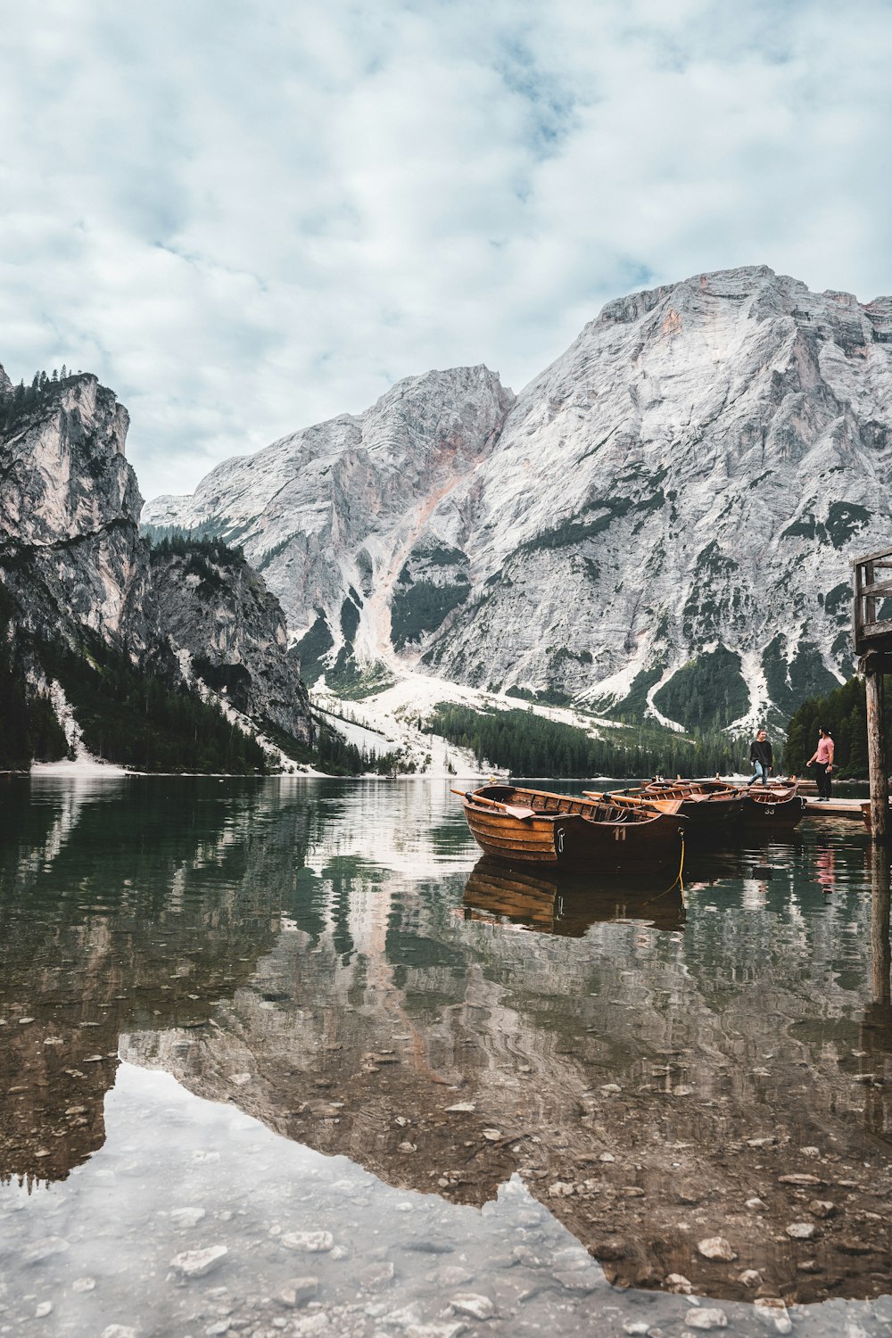 um barco em um lago com montanhas nevadas no fundo