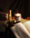A warm, inviting nook with plush cushions and a stack of favorite books beside a flickering candle.