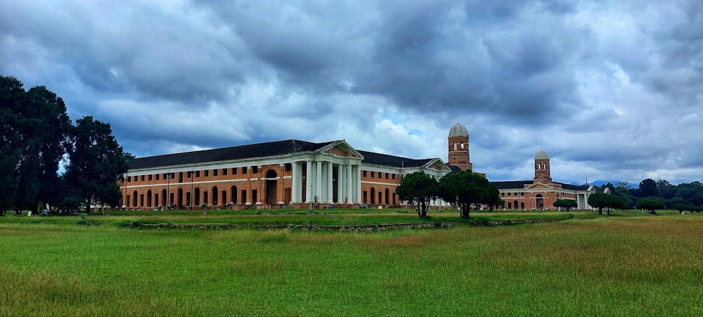 a large building with columns and a green lawn in front of it