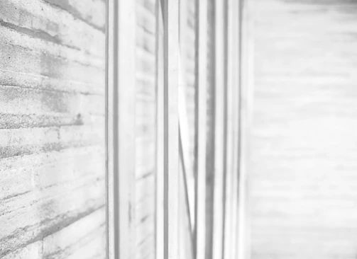 Close-up of textured concrete walls blending with wooden elements in a minimalist design.