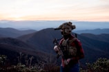 a man wearing a helmet and standing on a mountain