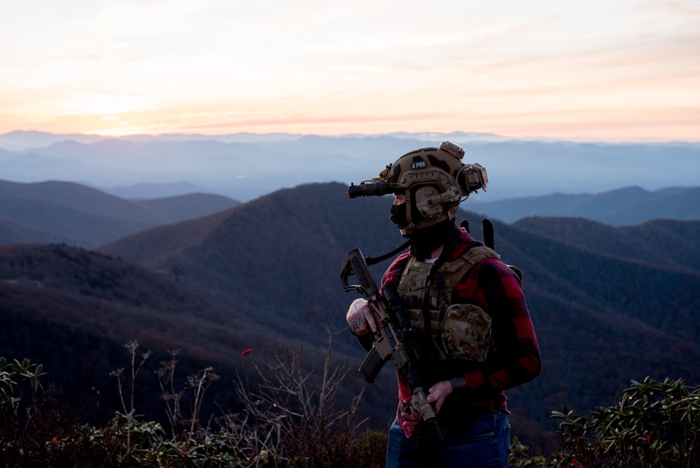 a man wearing a helmet and standing on a mountain