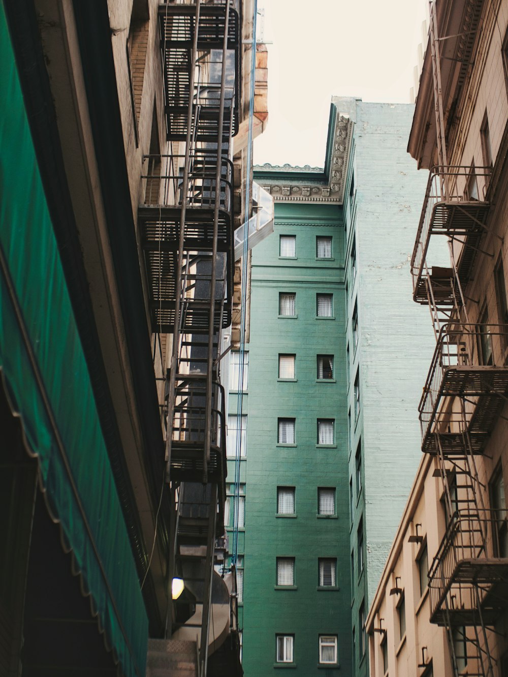 a building with balconies and a green wall