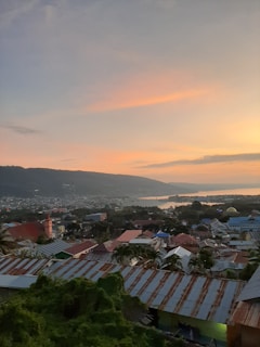 Sunset view over a Balkan coastal town with old red-roofed buildings and the sea in the background